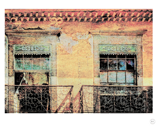 Close-up of weathered building with two ornate ironwork balconies and peeling paint. Fine art photography by RLF Photography