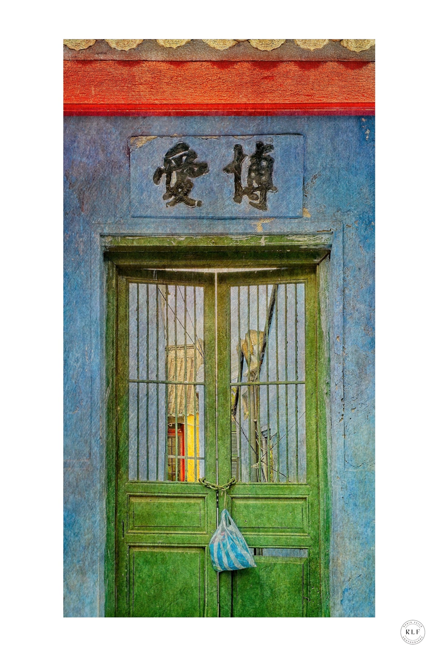 Vibrant green double doors with metal bars, Chinese sign above, and a striped bag hanging on the door. Blue walls and red beams. Fine art photography by RLF Photography