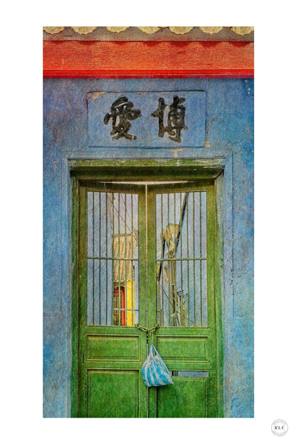 Vibrant green double doors with metal bars, Chinese sign above, and a striped bag hanging on the door. Blue walls and red beams. Fine art photography by RLF Photography