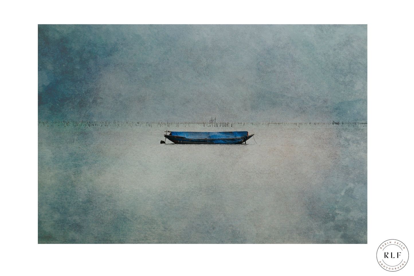 Minimalist photograph of a blue boat floating on calm water, with soft grey and blue tones, capturing peaceful solitude. Fine art photography by RLF Photography.