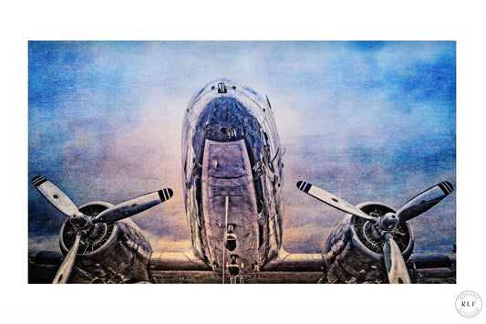 Vintage McDonnell Douglas DC3 vintage aircraft with polished chrome fuselage and propellers, set against a cloudy blue sky. Fine art photography by RLF Photography