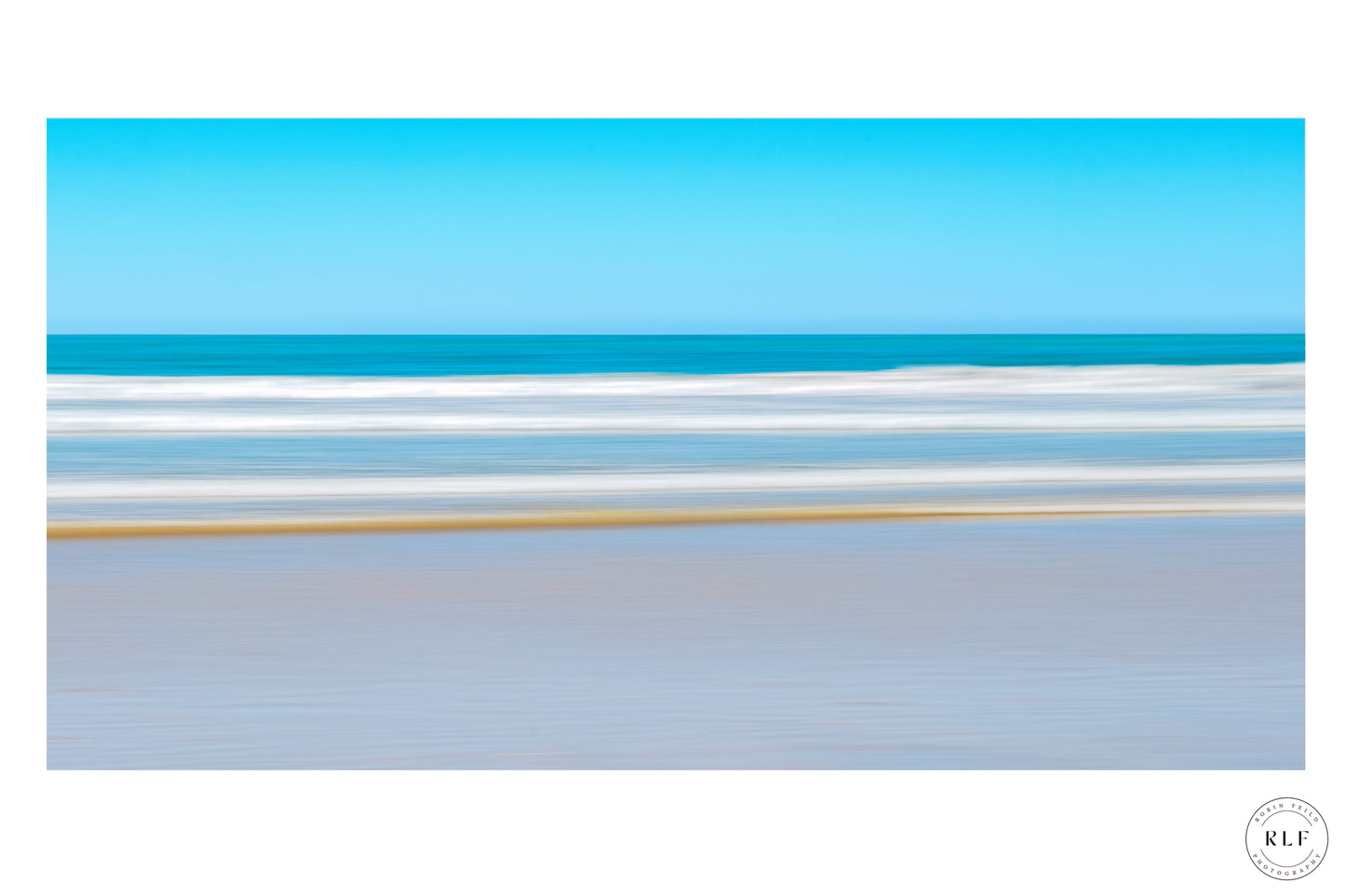 Minimalist seascape with clear blue sky, gentle ocean waves, and a sandy shoreline. Fine Art Photography by RLF Photography