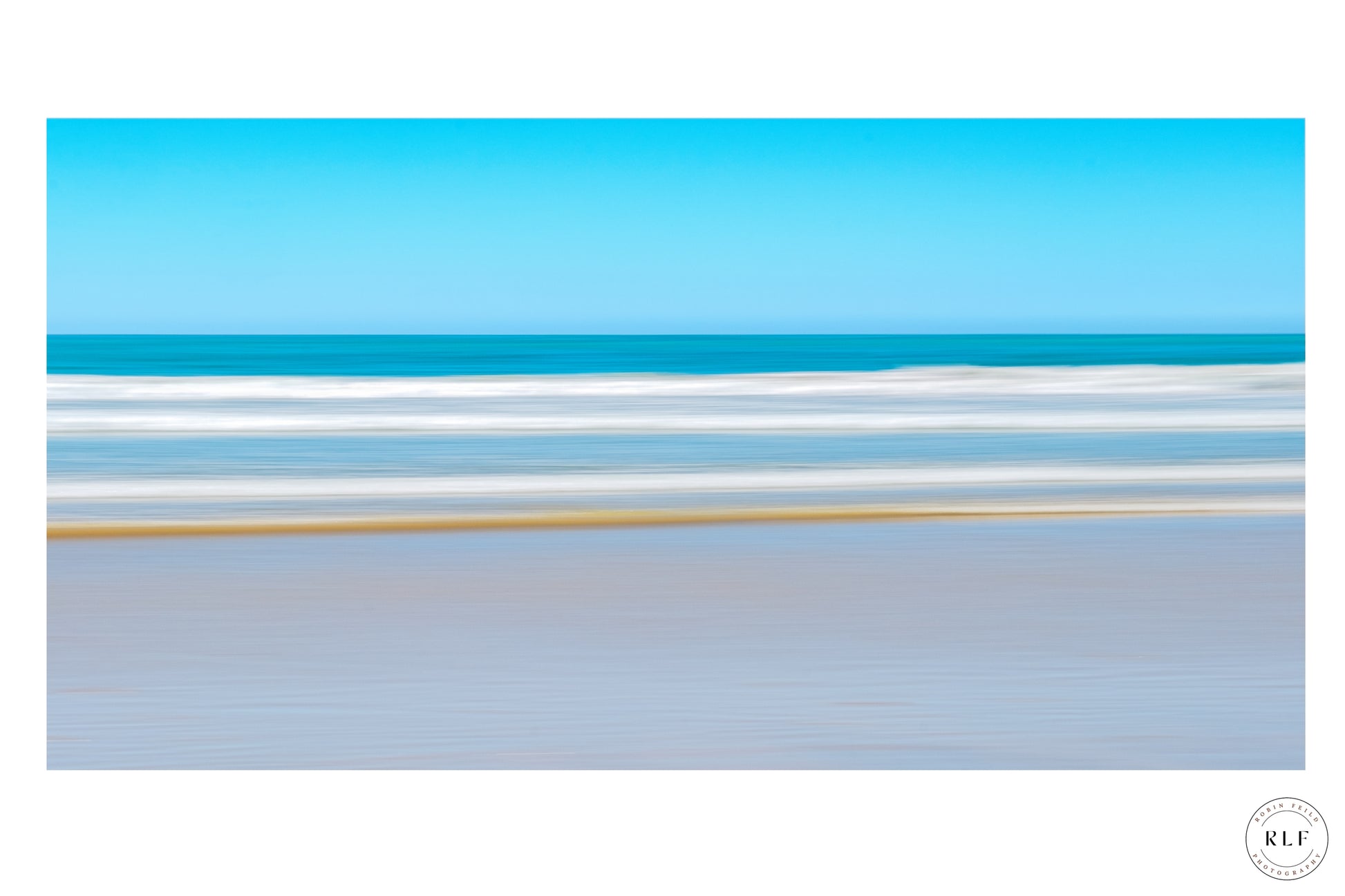 Minimalist seascape with clear blue sky, gentle ocean waves, and a sandy shoreline. Fine Art Photography by RLF Photography